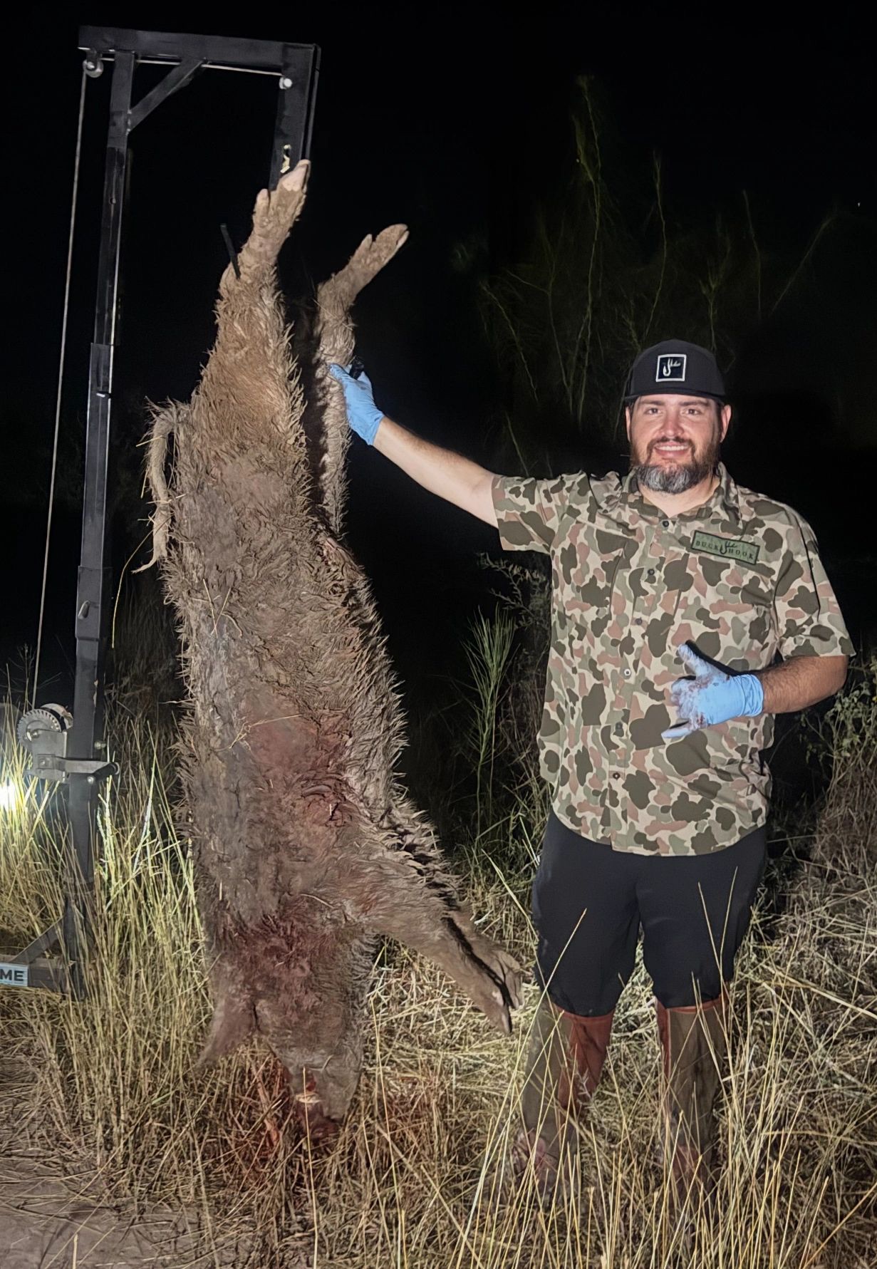 Hunter with a hanging hog